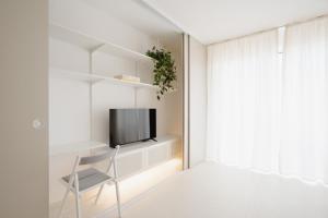 a living room with a chair and a television at Apartment Toffino Trnava - free private parking in Trnava