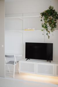 a living room with a tv on a white entertainment center at Apartment Toffino Trnava - free private parking in Trnava +9 photos