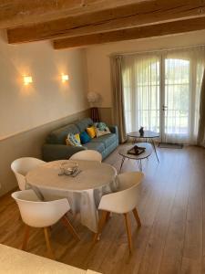 a living room with a couch and a table and chairs at Appartement T2 sur le Golf de Saint Endréol,spa,piscine in La Motte