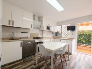a kitchen with white cabinets and a table and chairs at Bonito adosado a pocos minutos de Granada in Granada