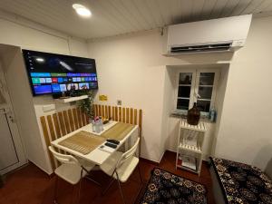 a room with a table and a tv on the wall at Sobreira Stone Cottage in Peso da Régua