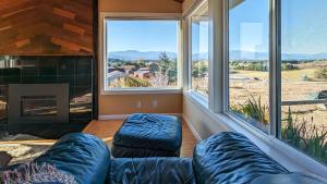 Una sala de estar con un sofá y grandes ventanales. en SQ Olympic-View-Cottage, en Sequim