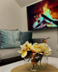 a vase with flowers on a table in a living room at Ruža vetrova A3 dupleks in Nova Varoš