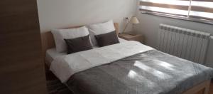 a bed with white sheets and pillows in a bedroom at Ruža vetrova A3 dupleks in Nova Varoš