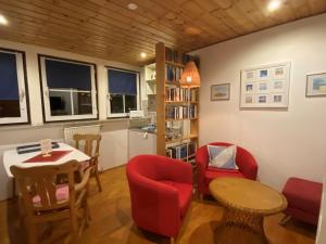 a living room with a table and chairs and a kitchen at Schumacher's Landhaus - Bücherhotel in Friedeburg