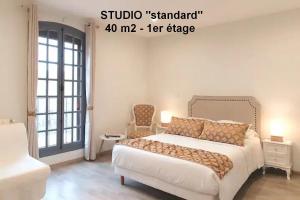 a bedroom with a large white bed and a chair at Studios MISTRAL21 en Camargue in Salin-de-Giraud