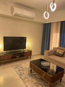 a living room with a flat screen tv and a couch at Chalet in marassi marina pool view exm80 in El Alamein