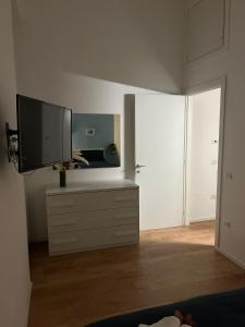 Una sala de estar con un televisor de pantalla plana sobre una cómoda. en Domus Velia, en Salerno