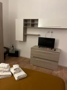sala de estar con TV y tocador con toallas en Domus Velia, en Salerno