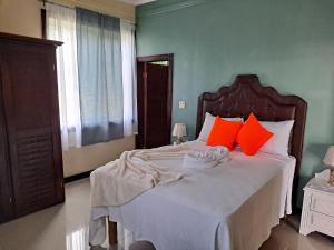 a bedroom with a large bed with orange pillows at Blue Seas Two in Montego Bay +54 photos