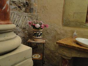 a vase of flowers sitting on a table next to a sink at Palazzo Ronchelli in Castello Cabiaglio