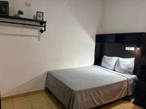 a bedroom with a bed with a black headboard at Hotel La Casona in Villahermosa