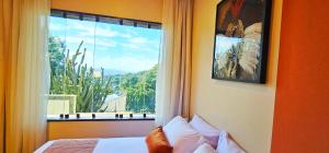a bedroom with a large window with a view at Cozy House in Rio de Janeiro