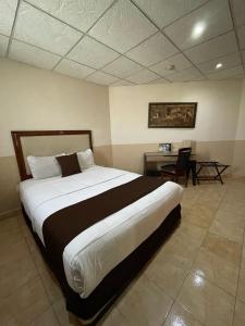 a bedroom with a large bed and a desk at El Regio in Monterrey