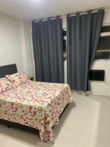 a bedroom with a bed and blue curtains at Melhor hospedagem e vista in São Vicente