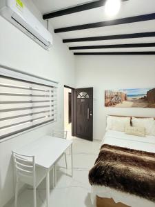 a bedroom with a bed and a table and a window at Casa Bendita 201 Espectacular in Medellín
