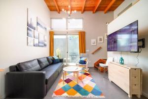 un soggiorno con un divano e una TV di #StayInMyDistrict Buckman Spacious Modern Rowhouse a Portland