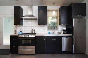 una cucina con armadi neri, piano cottura e frigorifero di #StayInMyDistrict Buckman Spacious Modern Rowhouse a Portland