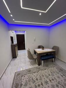 uma sala de jantar com uma mesa e cadeiras e paredes azuis em Golden Real Estate em Madinaty