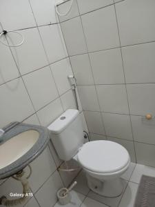 a white bathroom with a toilet and a sink at Cantinho da bel in Maragogi +8 photos
