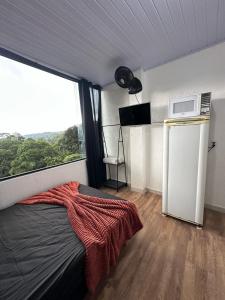a bedroom with a bed and a large window at KitNet Mobiliada Serra Cantareira in Caieiras
