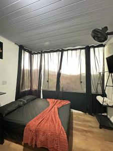 a bedroom with a bed and a large window at KitNet Mobiliada Serra Cantareira in Caieiras