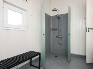 a bathroom with a shower with a bench and a window at 6 person holiday home in Bjert in Binderup Strand +23 photos
