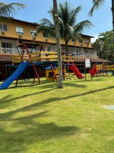 un parco con attrezzature da gioco colorate di fronte a un edificio di Angra Green Coast Residence Service e Marina ad Angra dos Reis