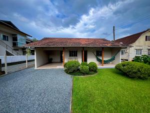 a house with a green yard in front of it at Casa Jardinada in Pomerode