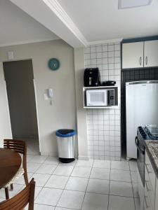 a kitchen with a refrigerator and a microwave at A melhor vista de São Vicente in São Vicente