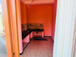 a kitchen with orange walls and black counter tops at Galle srilanka in Balapitiya