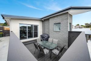 a patio with a table and chairs on a balcony at Villa 4 NEW 3Bed 2 Bath in Warrane