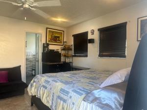 een slaapkamer met een bed, een stoel en ramen bij My Garden in Miami Florida in Palmetto Bay