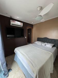 Un dormitorio con una cama y un ventilador de techo. en Apartamento 2 Quartos Próximo a Praia, en Rio das Ostras