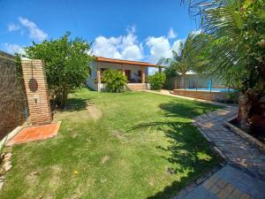 a backyard of a house with a grass yard at Casa Florida in Beberibe
