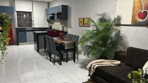 a living room with a table and a kitchen at Apartamento con Rooftop cerca de la Playa in Manzanillo