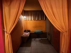 a bathroom with a toilet and a window with curtains at Motel Cocovi in Ciudad Lujan de Cuyo