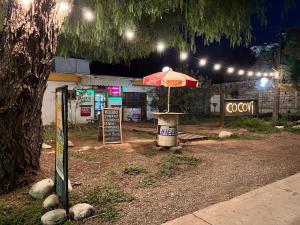 an umbrella in front of a store at night at Motel Cocovi in Ciudad Lujan de Cuyo