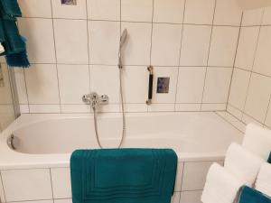 y baño con bañera y toalla verde. en Ferienwohnung Monschauer Land, en Monschau