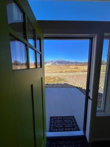 an open door with a view of a field at Posh Cottage Wine Country Mountain View Retreat in Palisade +3 photos