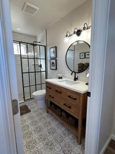a bathroom with a sink and a mirror and a toilet at Posh Cottage Wine Country Mountain View Retreat in Palisade