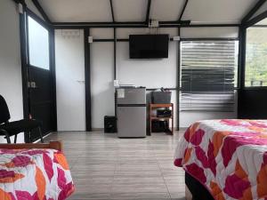 a room with two beds and a flat screen tv at Cabaña del Rio in Choachí
