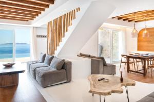 a living room with a couch and a table at Ria Mar Villas & Suites by Live&Travel in Houlakia
