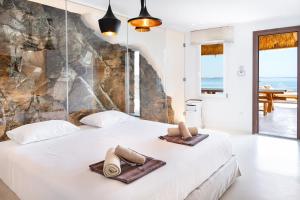 a bedroom with a bed with towels on it at Ria Mar Villas & Suites by Live&Travel in Houlakia +44 photos