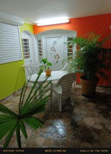 einen Tisch und Stühle in einem Zimmer mit Pflanzen in der Unterkunft T-Syssy Loft, Marin direction Sainte Anne et routes des plages du SUD in Le Marin