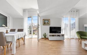 a white dining room with a table and a tv at 2 Bedroom Gorgeous Apartment In Vezac in Vezac