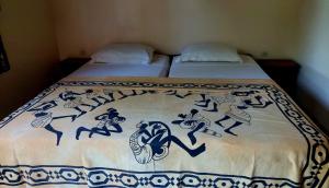 a bed with a blue and white blanket on it at Bolongs Passion in Cap Skirring
