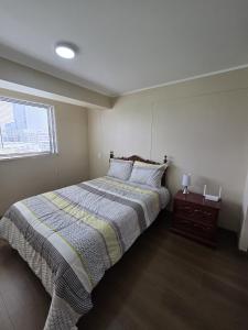 a bedroom with a large bed and a window at AMPLIO DEPARTAMENTO EN JESÚS MARÍa in Lima