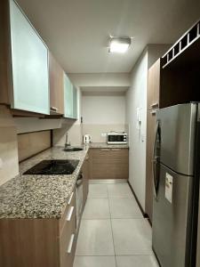 a kitchen with a stainless steel refrigerator and cabinets at Departamento Condominio del Alto 3 H&L in Rosario