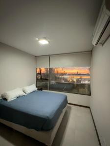 a bedroom with a bed and a large window at Departamento Condominio del Alto 3 H&L in Rosario